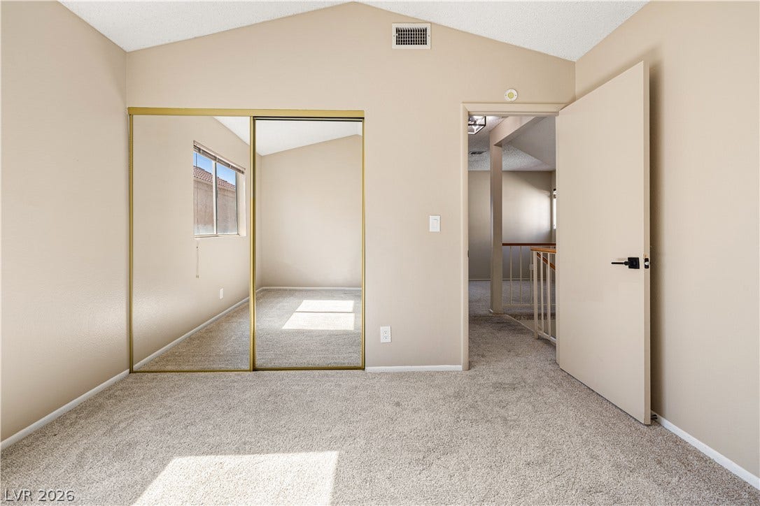 325 Manor Street, Las Vegas, NV 89145 Vaulted ceilings and plush carpeting enhance this bedroom, which includes mirrored closet doors.