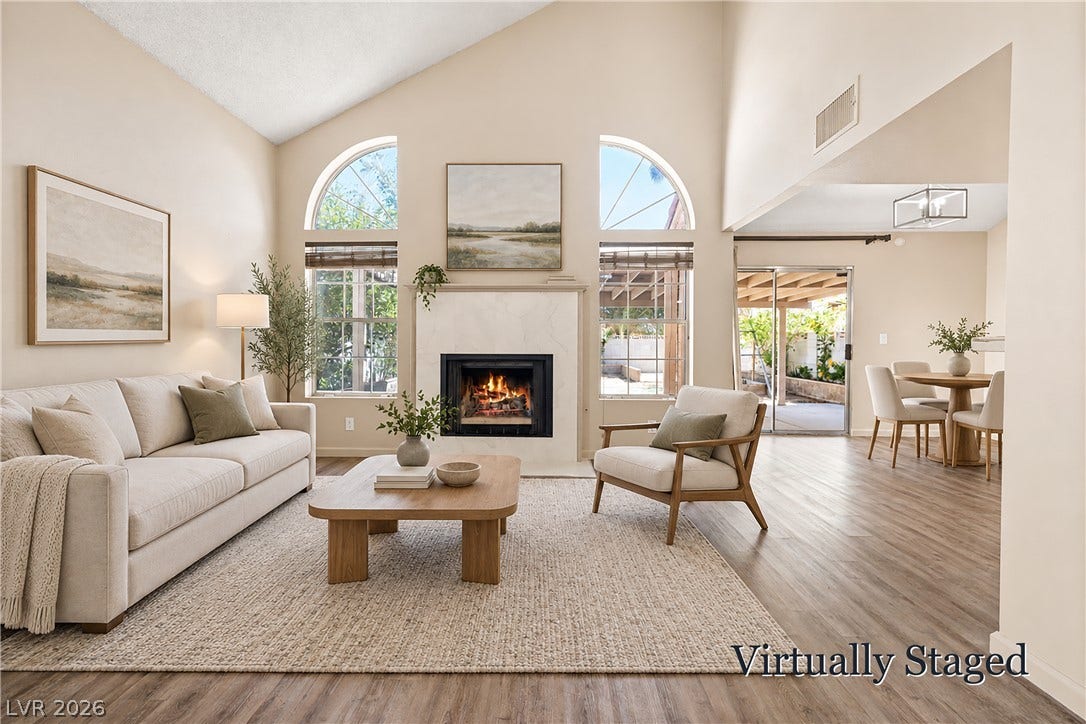 325 Manor Street, Las Vegas, NV 89145 High vaulted ceilings and arched windows frame a handsome fireplace in this open living area.