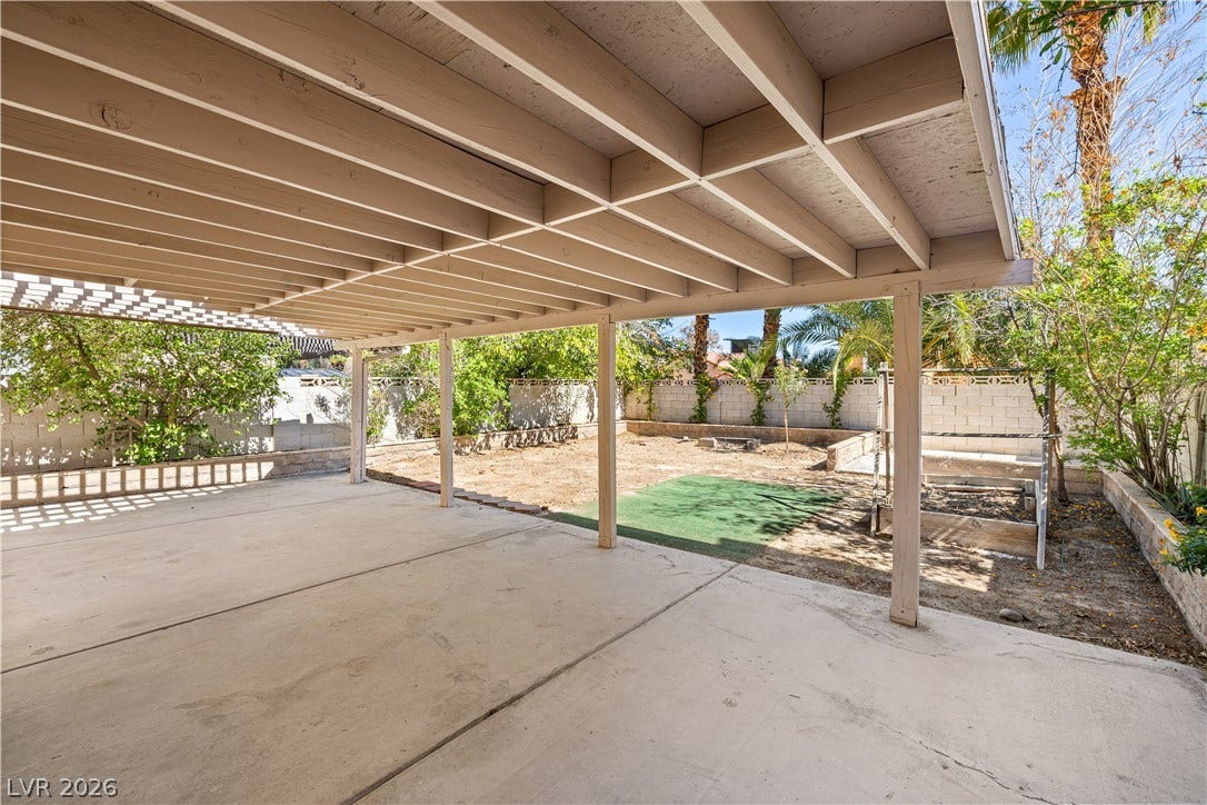 325 Manor Street, Las Vegas, NV 89145 A spacious covered concrete patio overlooks the private backyard with block fencing.