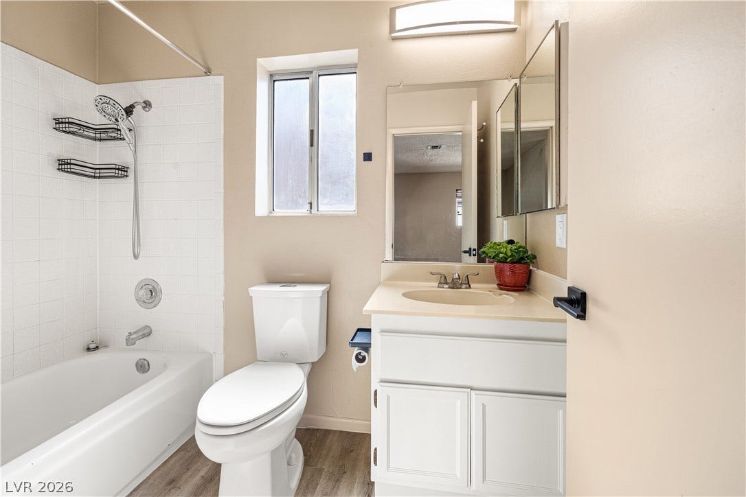 325 Manor Street, Las Vegas, NV 89145 Tiled tub surrounds and wood-look flooring enhance this functional bathroom layout.