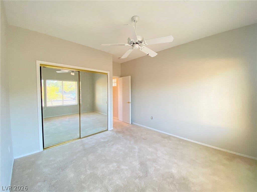 Soft carpeting underfoot and sliding mirrored closet doors define this serene bedroom space.