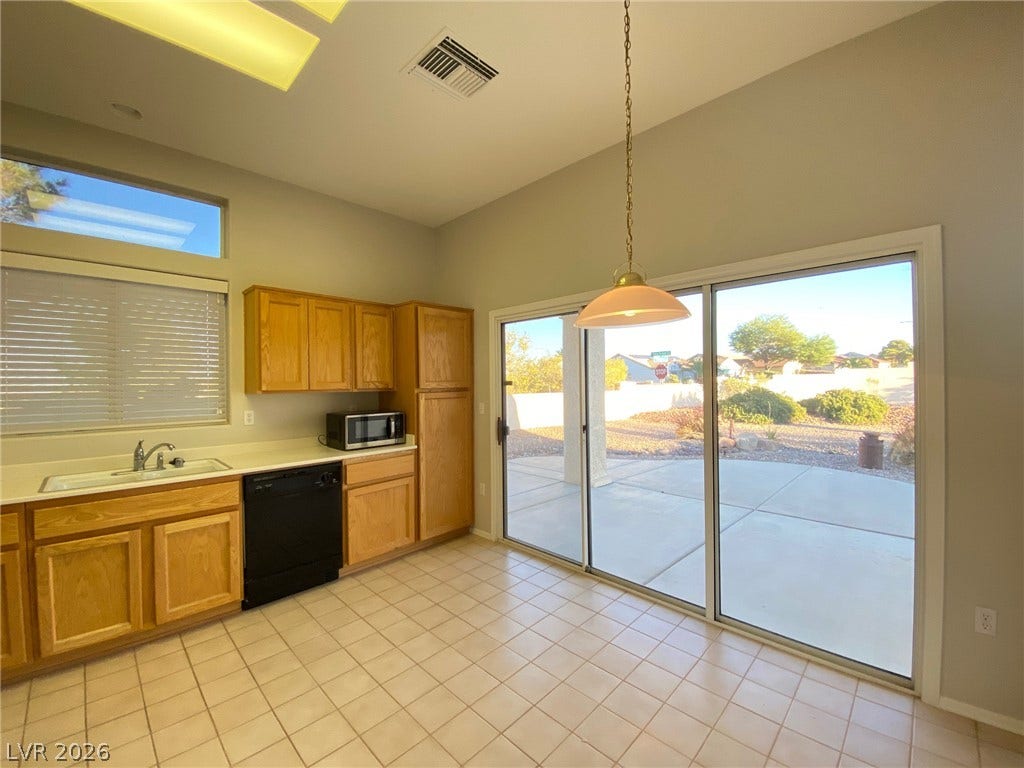 Tiled flooring and high ceilings elevate this functional kitchen space opening directly to the patio.
