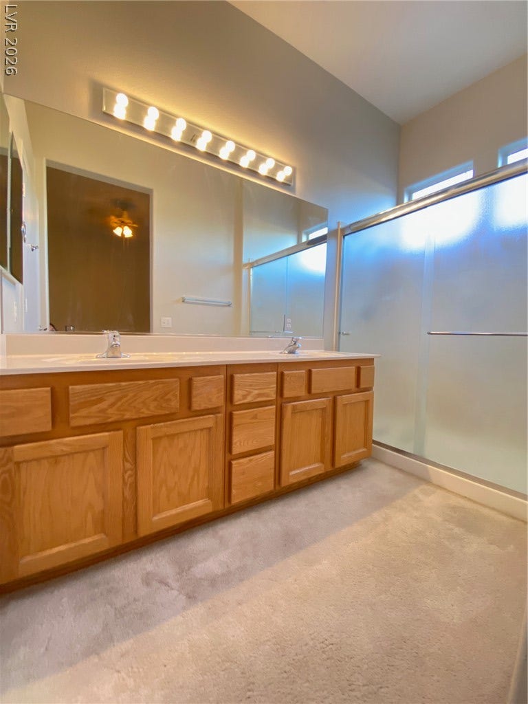 Ample wooden cabinetry and a large mirror define this functional vanity space.