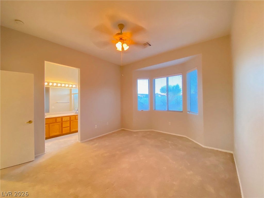 A spacious bedroom features a bay window and an attached bathroom.