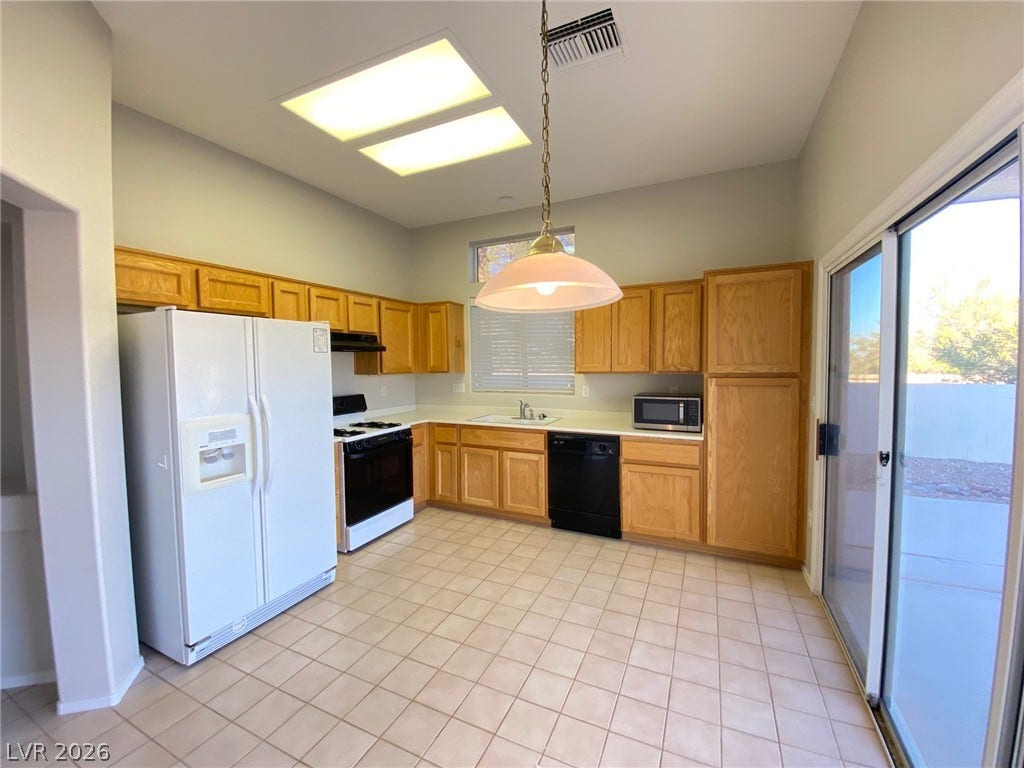 Natural light pours through the overhead skylight into this spacious kitchen featuring tile flooring.