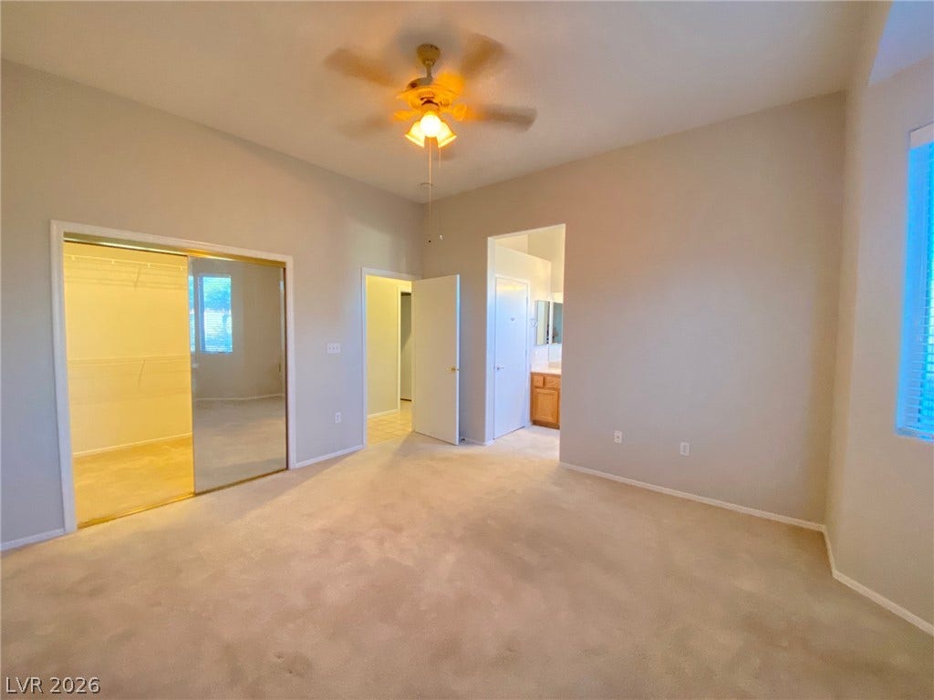 High ceilings and soft neutral carpeting define this spacious main bedroom suite.
