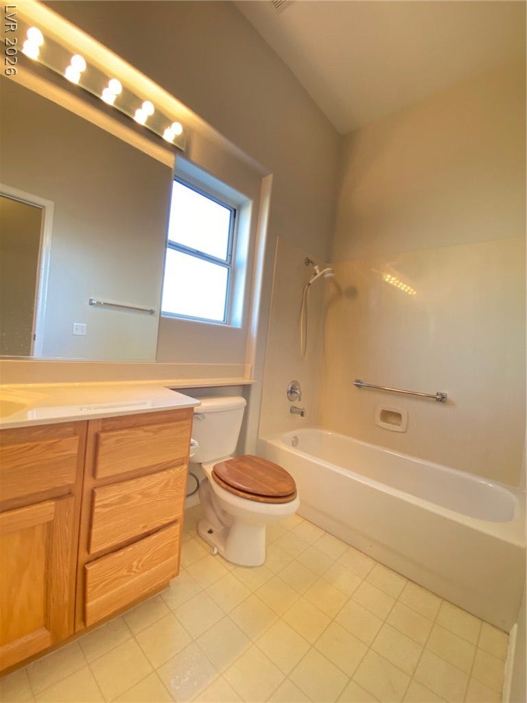 An inviting bathroom offers a wood vanity and a combined tub and shower setup.
