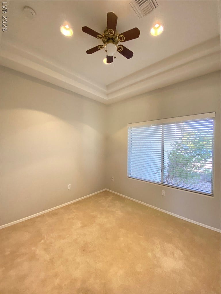 Plentiful natural light filters through the large window of this carpeted room.