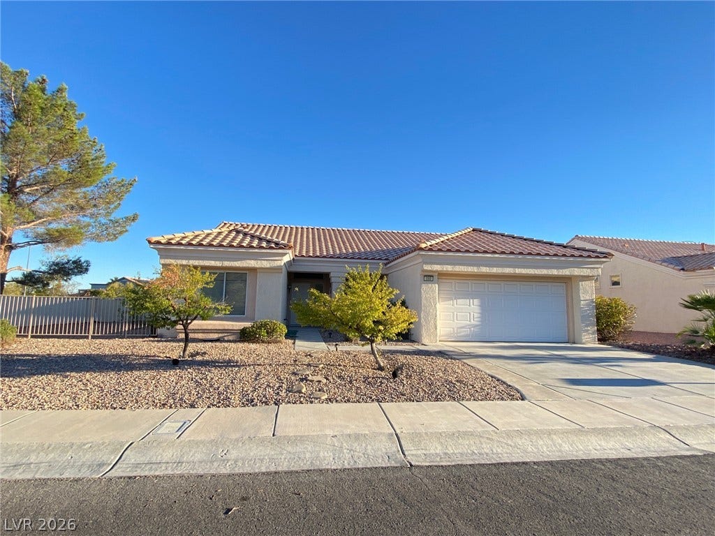 Classic tile roofing and low-maintenance desert landscaping define this neat single-story suburban residence.