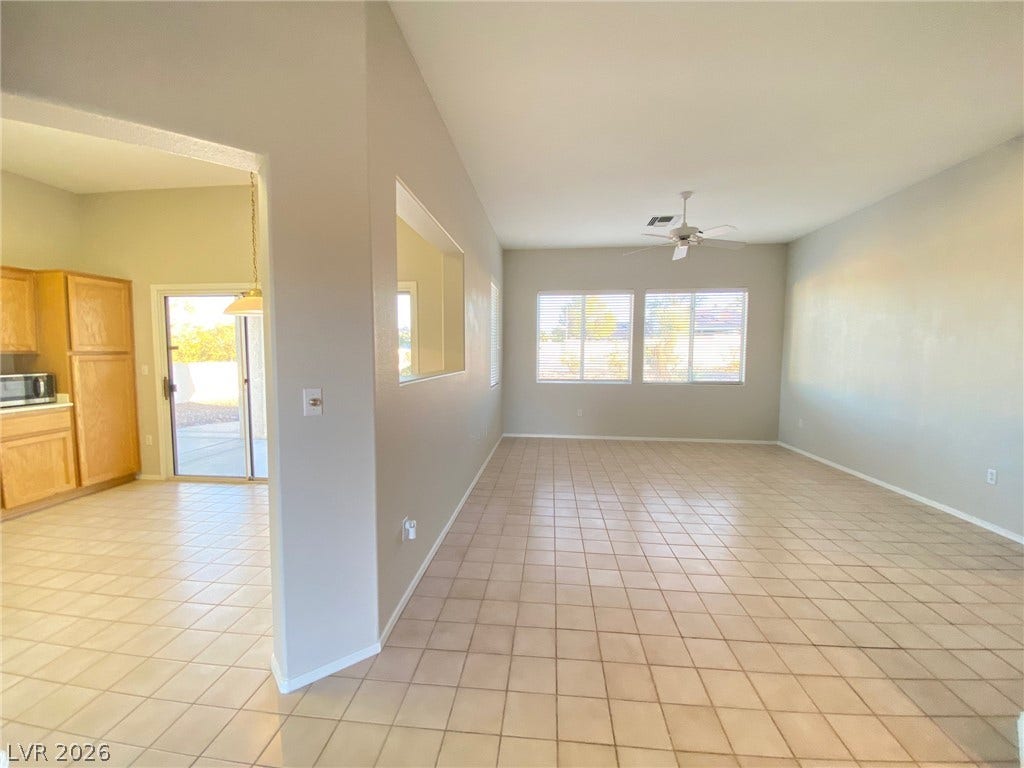 An open floorplan connects the tile-floored living area to the adjacent kitchen space.