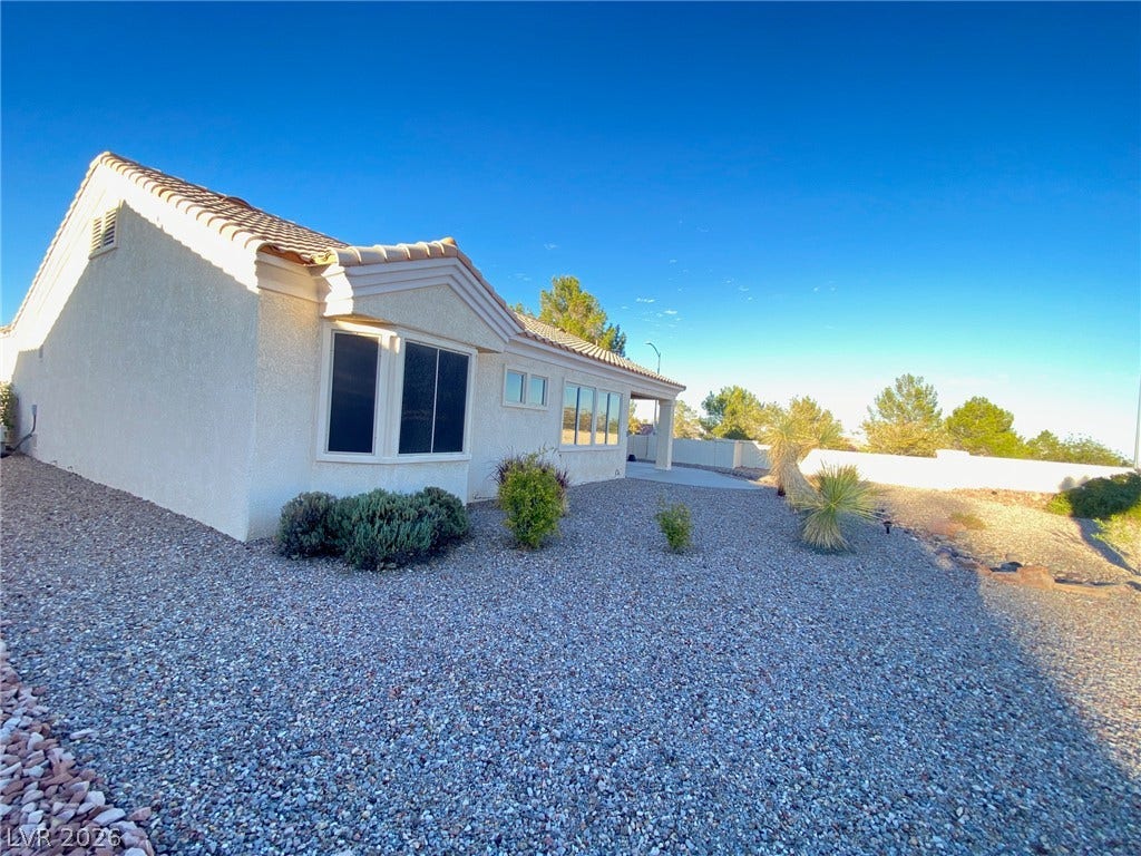 Desert landscaping and a tiled roof define the exterior of this low-maintenance stucco home.