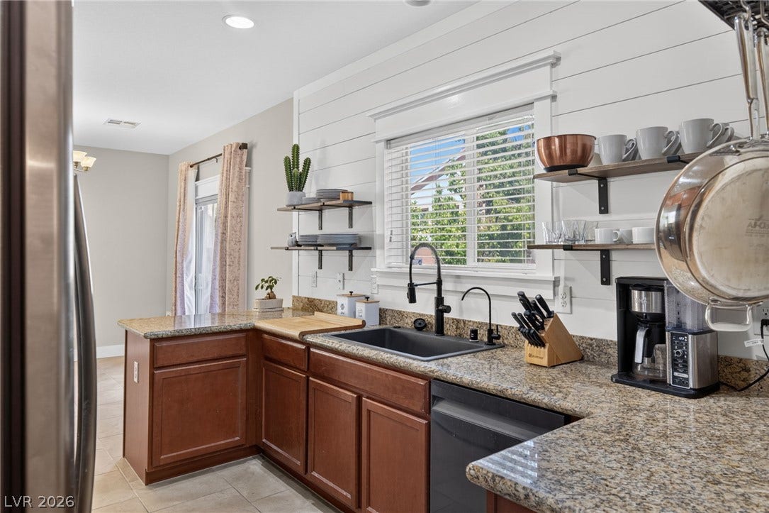 8112 Winterfell Place, Las Vegas, NV 89166 Granite countertops and rich wood cabinetry anchor this inviting kitchen space.