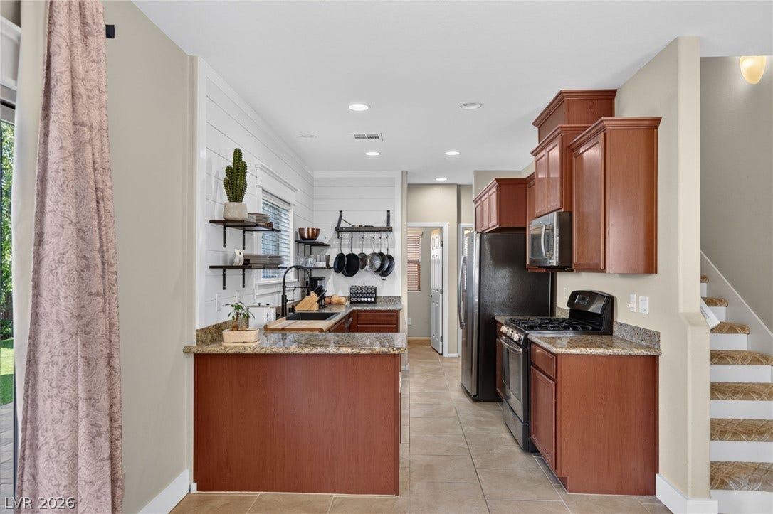 8112 Winterfell Place, Las Vegas, NV 89166 Gleaming stone countertops and classic wood cabinetry define this inviting culinary space.