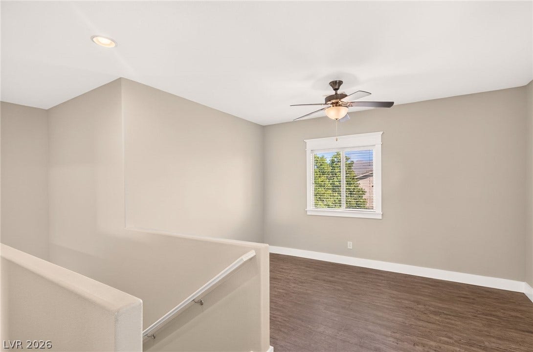 8112 Winterfell Place, Las Vegas, NV 89166 Rich wood-inspired flooring pairs beautifully with smooth neutral walls in this versatile upstairs landing.