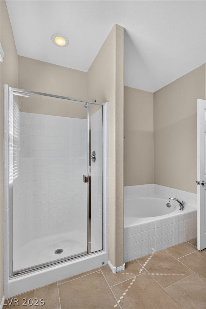 8112 Winterfell Place, Las Vegas, NV 89166 A glass-enclosed shower stand and a soaking tub sit adjacent to each other.