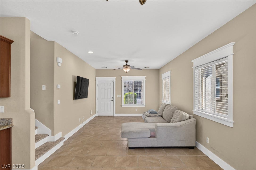 8112 Winterfell Place, Las Vegas, NV 89166 Tiled flooring and large windows with classic moldings define this open living space.