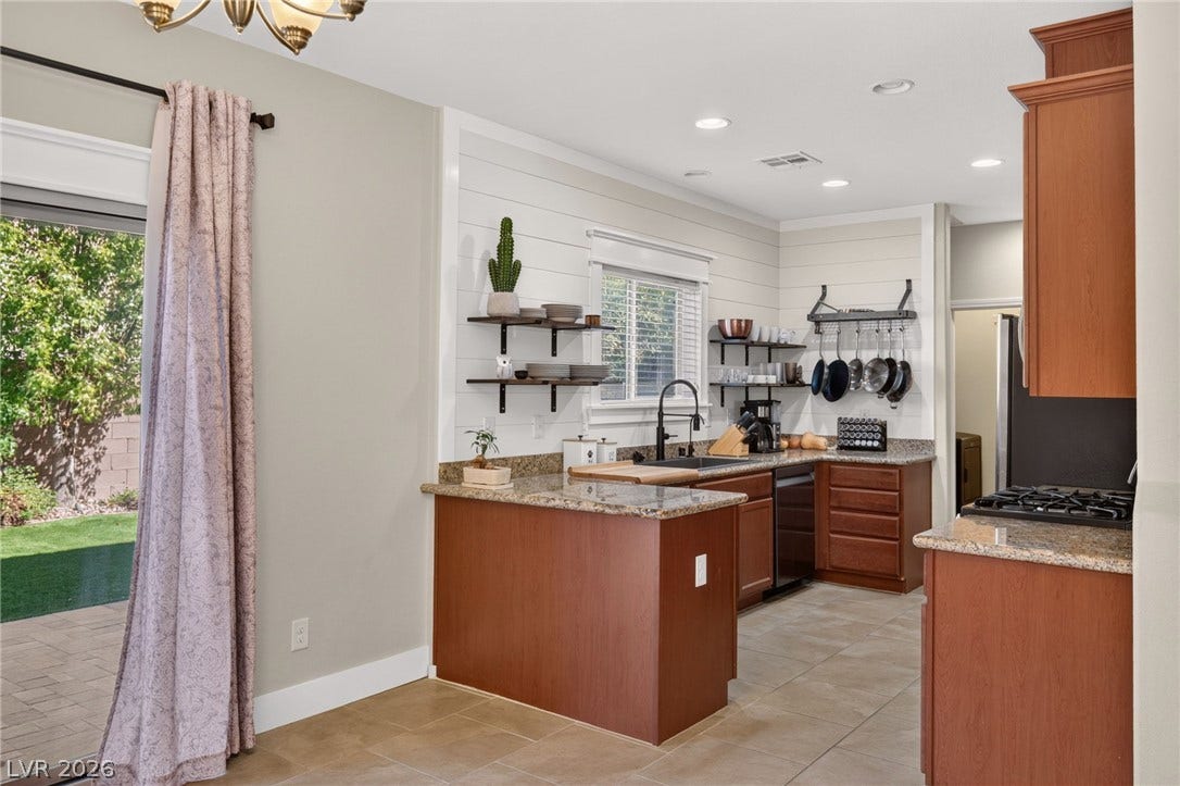 8112 Winterfell Place, Las Vegas, NV 89166 Rich wood cabinetry and warm granite countertops define this classic, open culinary space.