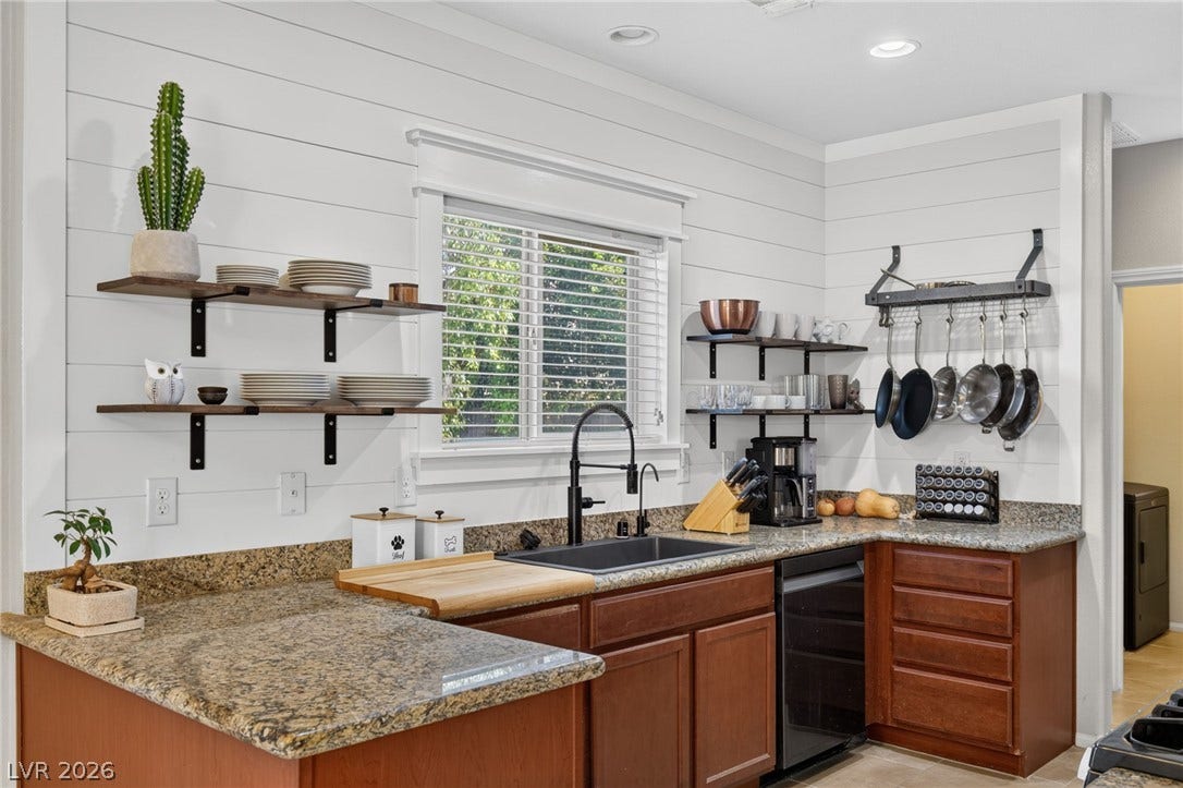 8112 Winterfell Place, Las Vegas, NV 89166 Rich granite countertops and horizontal wall paneling define this inviting culinary space.