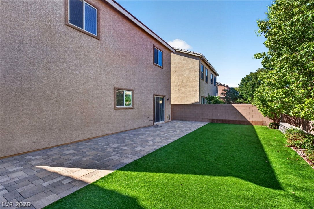 8112 Winterfell Place, Las Vegas, NV 89166 An inviting backyard features a spacious stone paver patio alongside a manicured lawn.