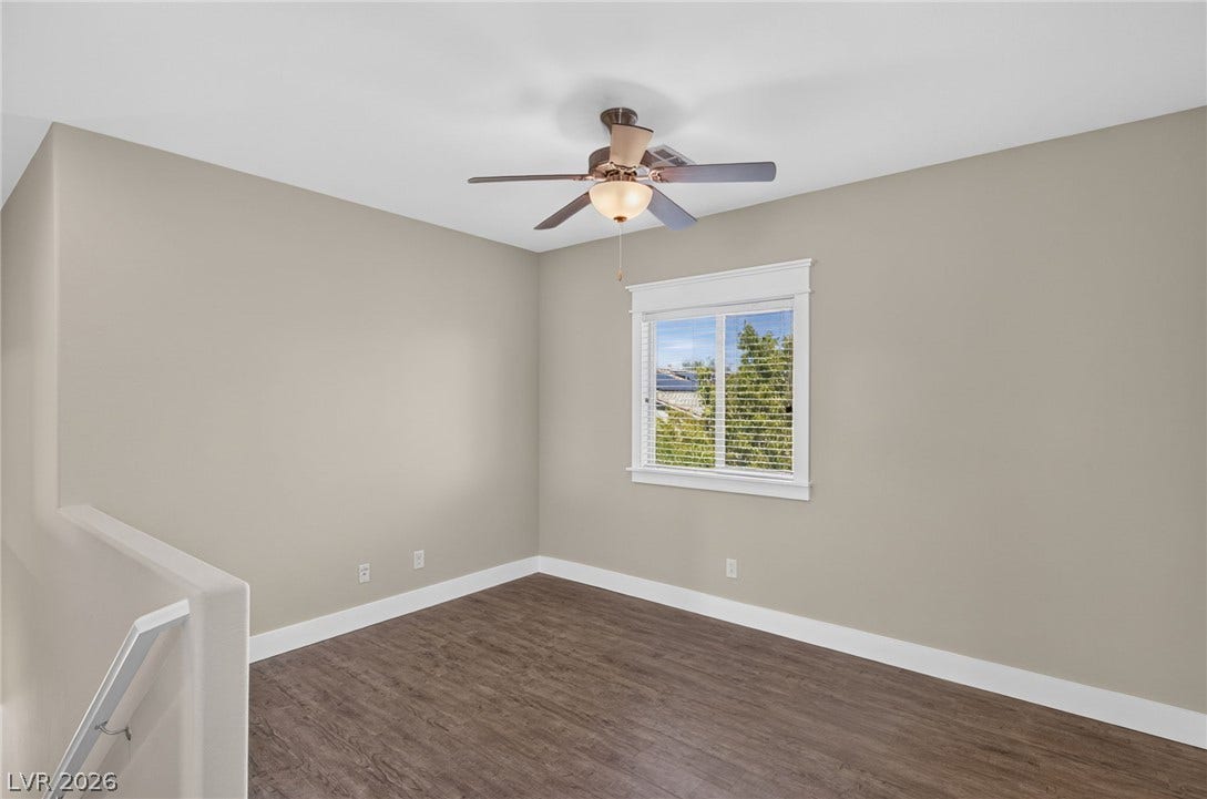 8112 Winterfell Place, Las Vegas, NV 89166 Rich wood-look flooring and a classic window frame highlight this versatile upper-level space.