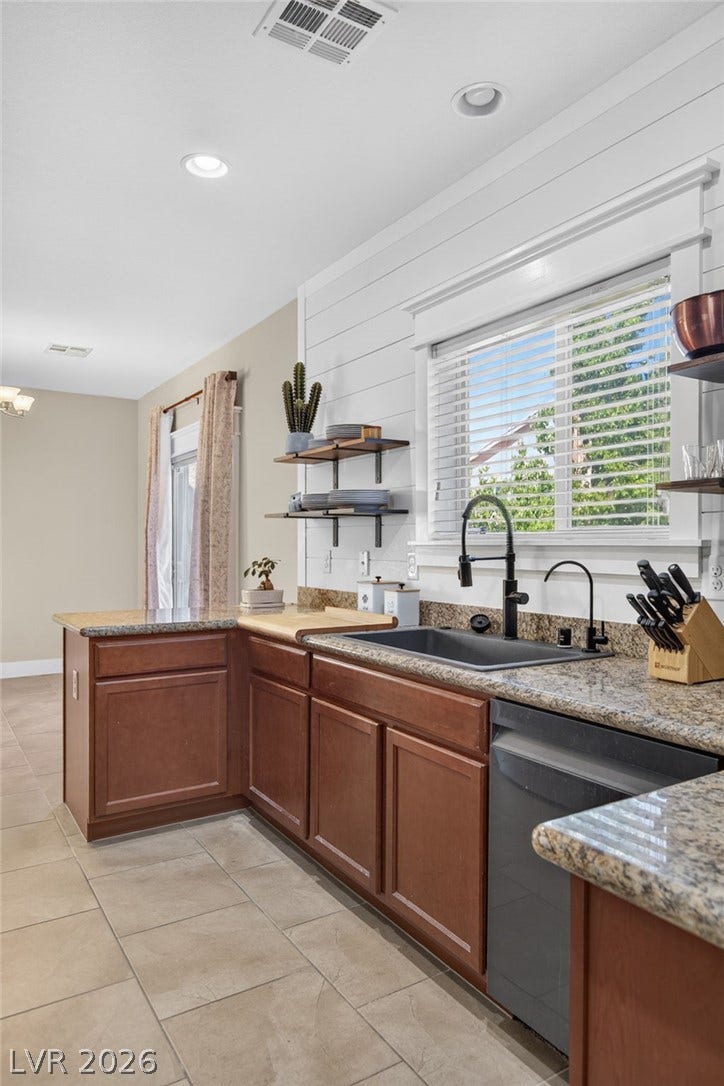 8112 Winterfell Place, Las Vegas, NV 89166 Granite countertops and rich wood cabinetry anchor this functional cooking space.