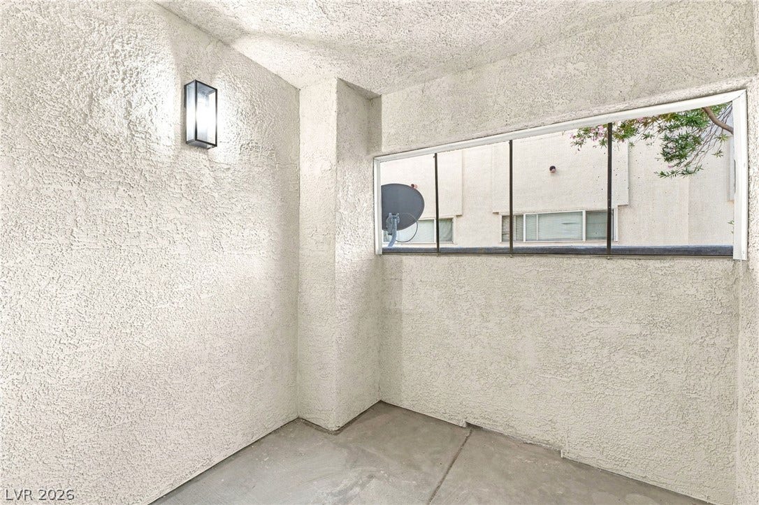 4500 W Lake Mead Boulevard, #102, Las Vegas, NV 89108 A private covered balcony features textured stucco walls and a clean concrete floor.