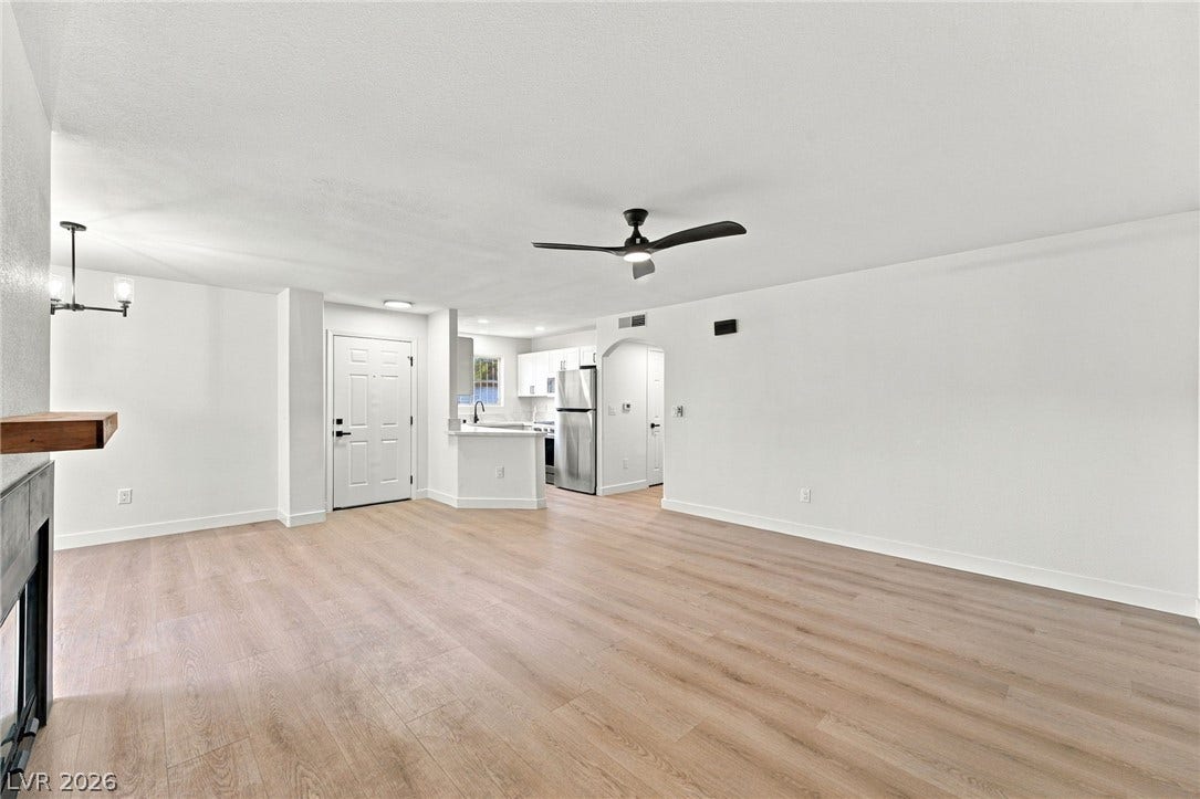 4500 W Lake Mead Boulevard, #102, Las Vegas, NV 89108 Smooth wood-look flooring anchors this open living space flowing seamlessly toward the kitchen.