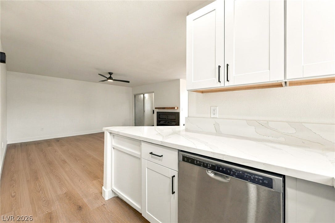 4500 W Lake Mead Boulevard, #102, Las Vegas, NV 89108 Crisp white cabinetry paired with stone countertops flows effortlessly into the main living space.