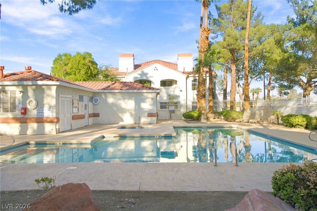 4500 W Lake Mead Boulevard, #102, Las Vegas, NV 89108 Mature palms and pine trees frame a sparkling community pool lined with concrete decking.