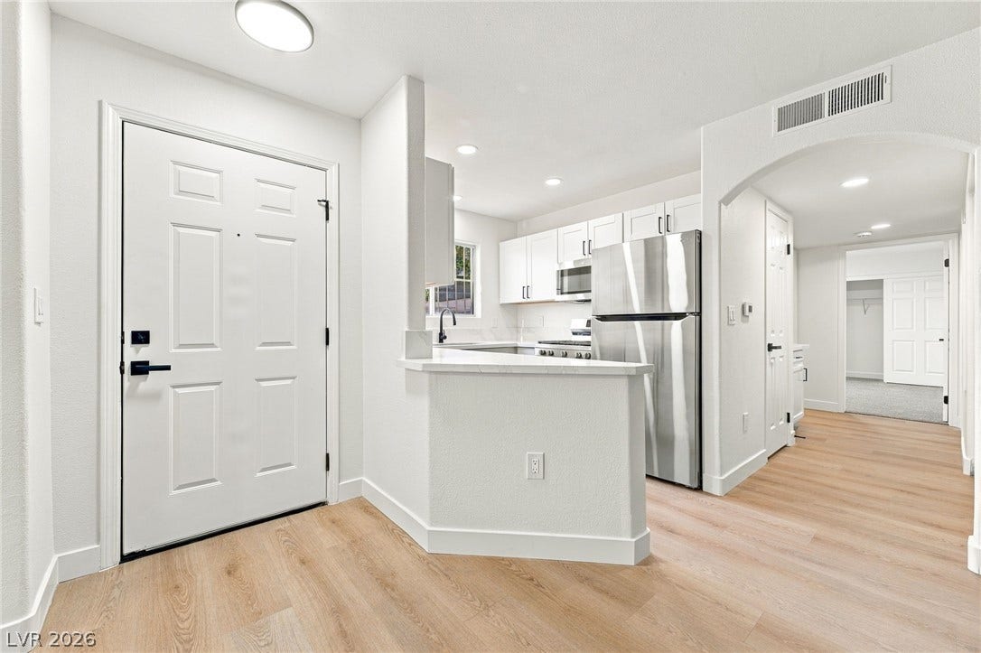 4500 W Lake Mead Boulevard, #102, Las Vegas, NV 89108 Clean lines and wood-style flooring connect the welcoming entry to the updated kitchen.
