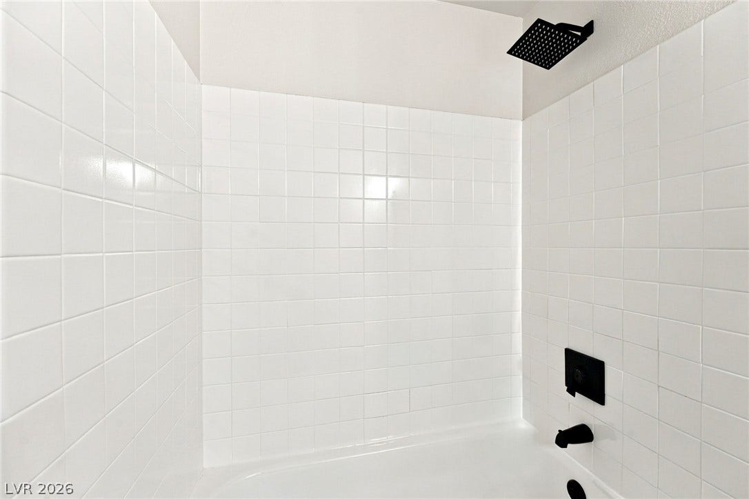 4500 W Lake Mead Boulevard, #102, Las Vegas, NV 89108 Clean square tiling and modern black hardware create a polished look in this shower.