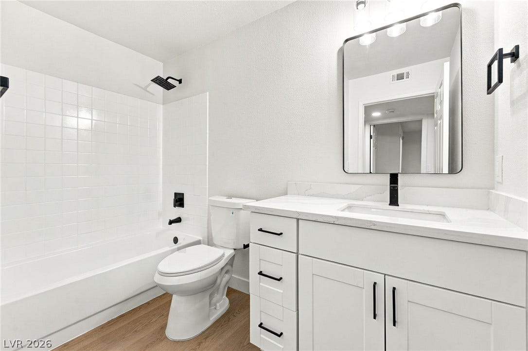 4500 W Lake Mead Boulevard, #102, Las Vegas, NV 89108 Clean lines and stone counters highlight this updated bathroom with wood-look flooring.
