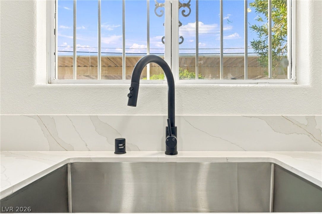 4500 W Lake Mead Boulevard, #102, Las Vegas, NV 89108 A modern gooseneck faucet pairs beautifully with stone countertops below a bright window.
