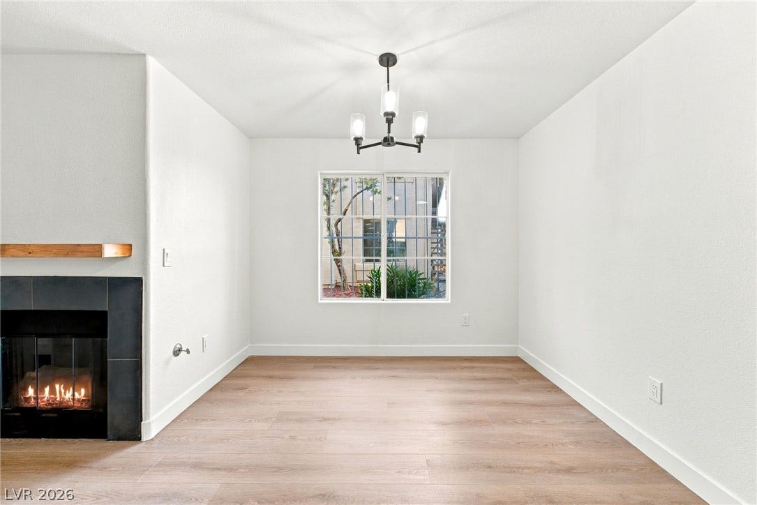 4500 W Lake Mead Boulevard, #102, Las Vegas, NV 89108 An inviting dining room features a modern fireplace and wide-plank wood flooring.