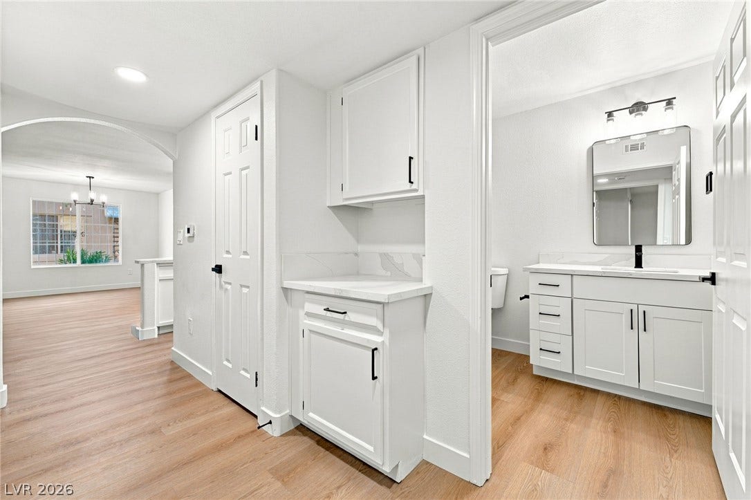 4500 W Lake Mead Boulevard, #102, Las Vegas, NV 89108 Smooth wood-look flooring connects the hallway built-ins to a modern powder room.