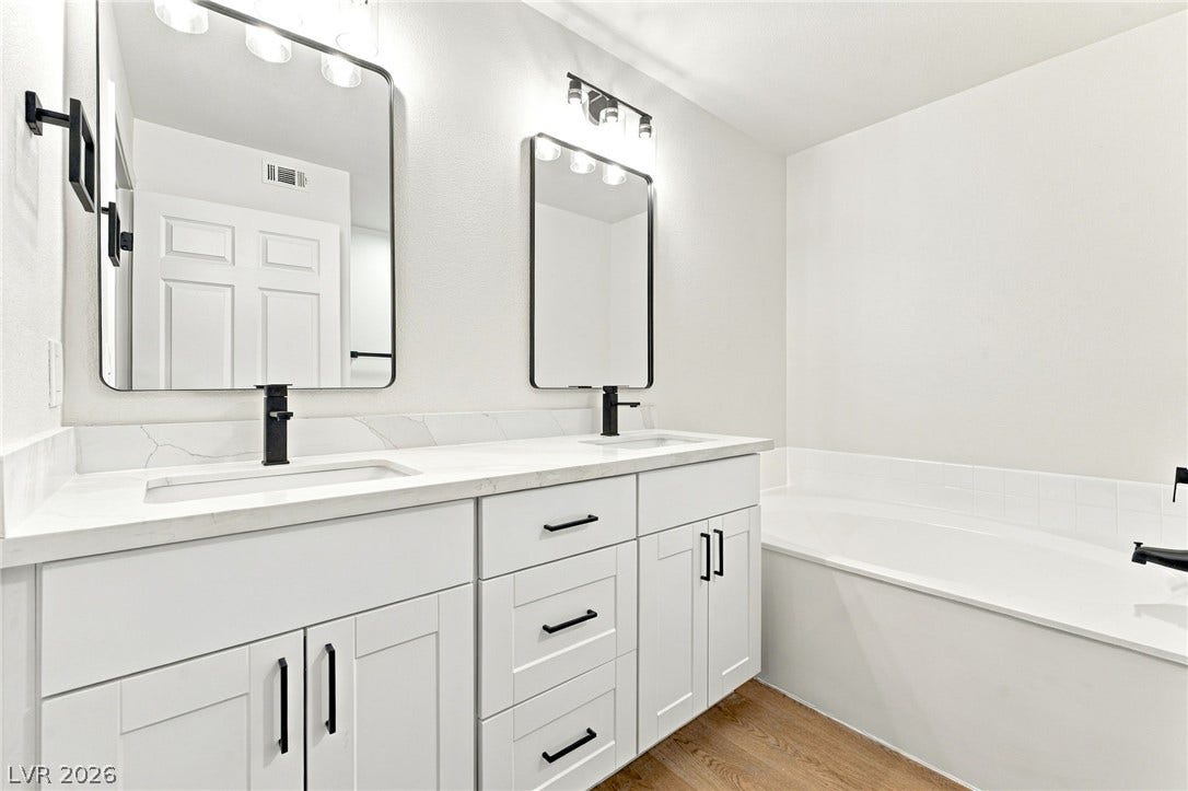 4500 W Lake Mead Boulevard, #102, Las Vegas, NV 89108 Clean lines and a spacious dual vanity define this modern bathroom with a soaking tub.