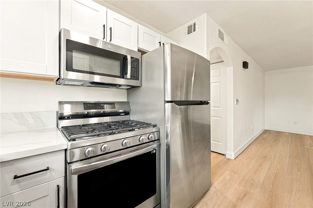 4500 W Lake Mead Boulevard, #102, Las Vegas, NV 89108 Stainless steel appliances complement clean white cabinetry and warm wood flooring.