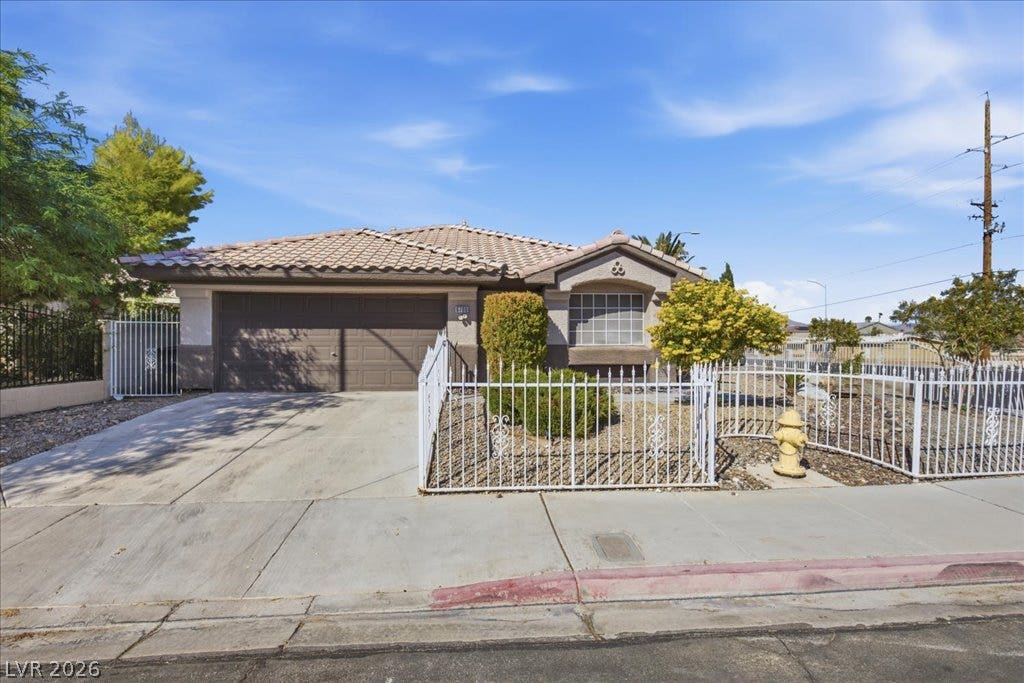A classic tiled roof and paved driveway define this welcoming single-story exterior.
