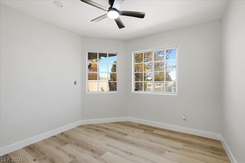 Multi-pane windows fill this comfortable room with natural light while highlighting the wood flooring.