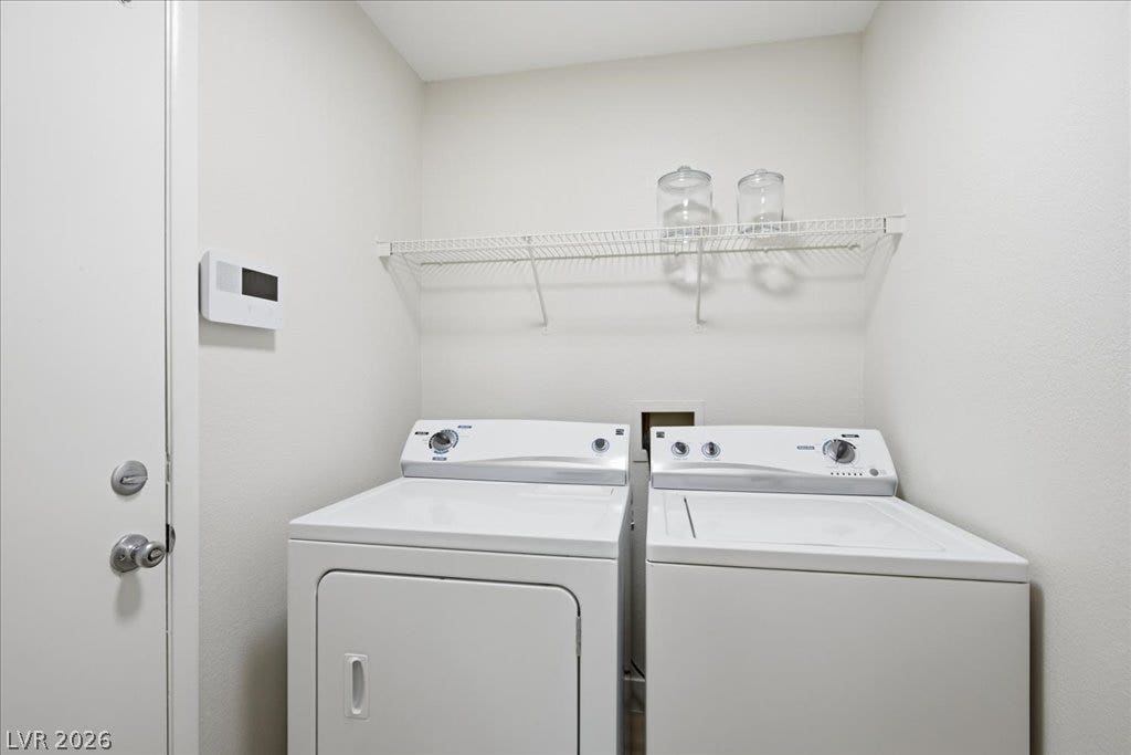 A dedicated laundry utility space offers practical storage shelving and hookups.