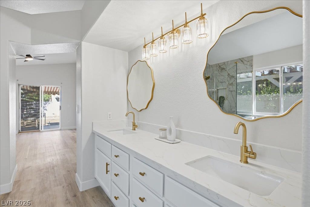 Gleaming stone counters and dual vanities anchor this beautifully updated washroom space.