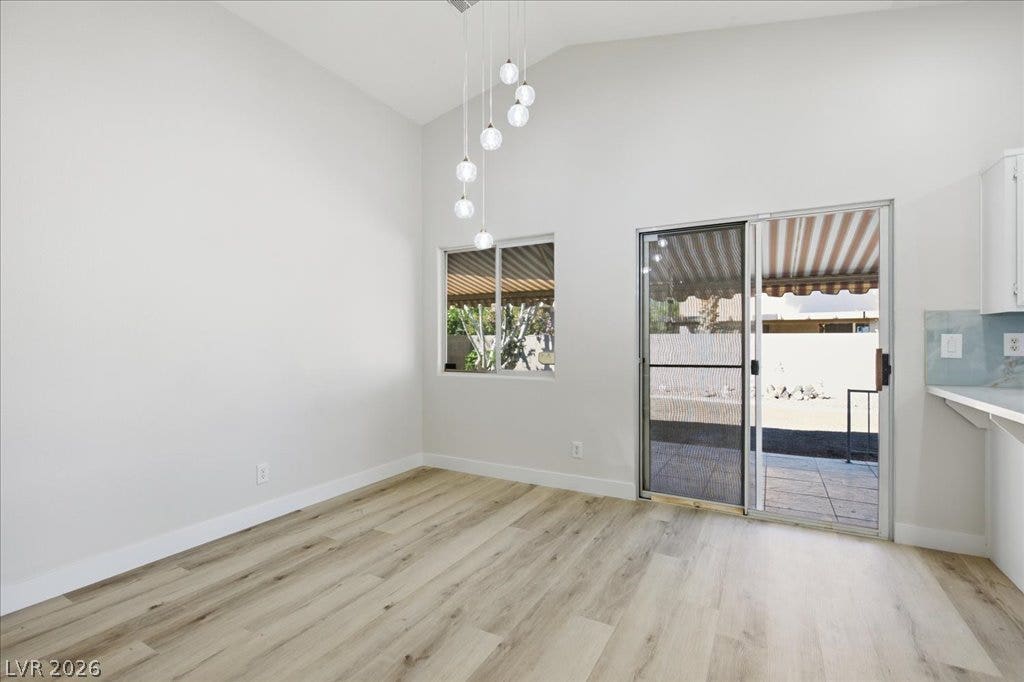 Sliding glass doors open to the patio from this dining area with vaulted ceilings.