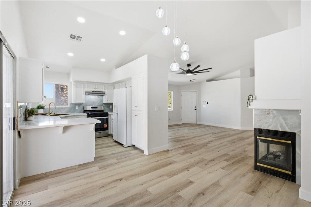 Gleaming wood floors anchor an airy open floorplan seamlessly connecting the kitchen and living areas.