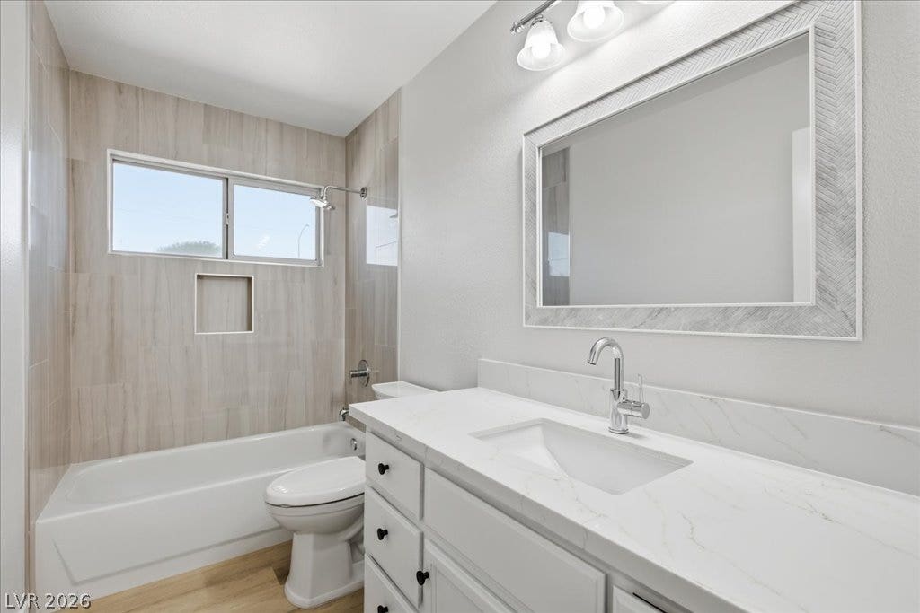 A classic bathtub shower combination sits adjacent to a contemporary vanity setup.