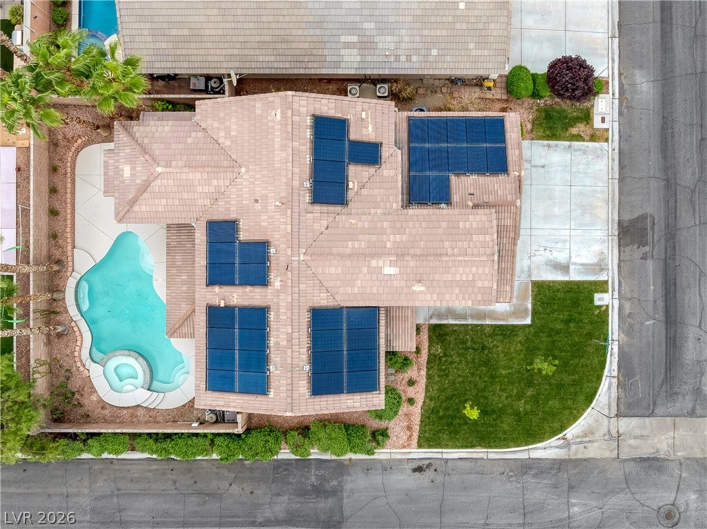 An aerial perspective showcases the solar-equipped tile roof alongside a backyard swimming pool and manicured lawn.