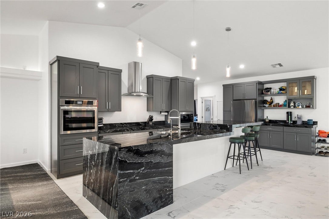 1601 W Calvada Boulevard, Pahrump, NV 89048 Dramatic dark granite countertops anchor this modern culinary space featuring vaulted ceilings