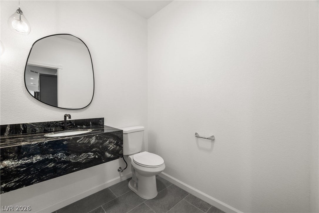 1601 W Calvada Boulevard, Pahrump, NV 89048 Floating dark granite vanity in the half-bath also has a Bluetooth enabled mirror