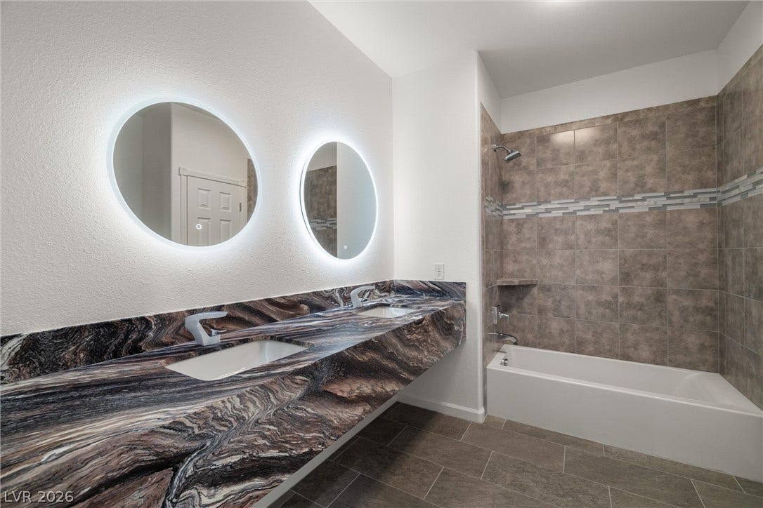 1601 W Calvada Boulevard, Pahrump, NV 89048 Striking granite counters and backlit mirrors elevate this modern dual sink bathroom