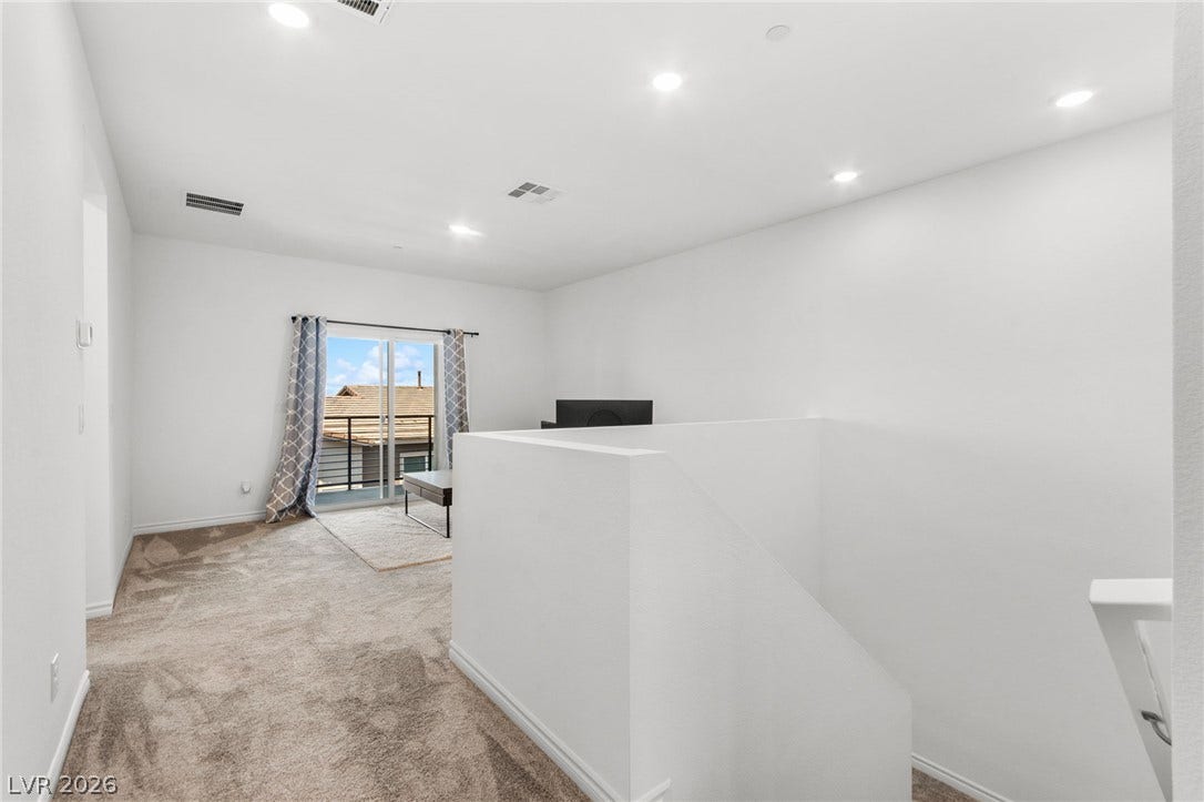 A versatile upper-level bonus room features a sliding glass door leading to an outdoor balcony.