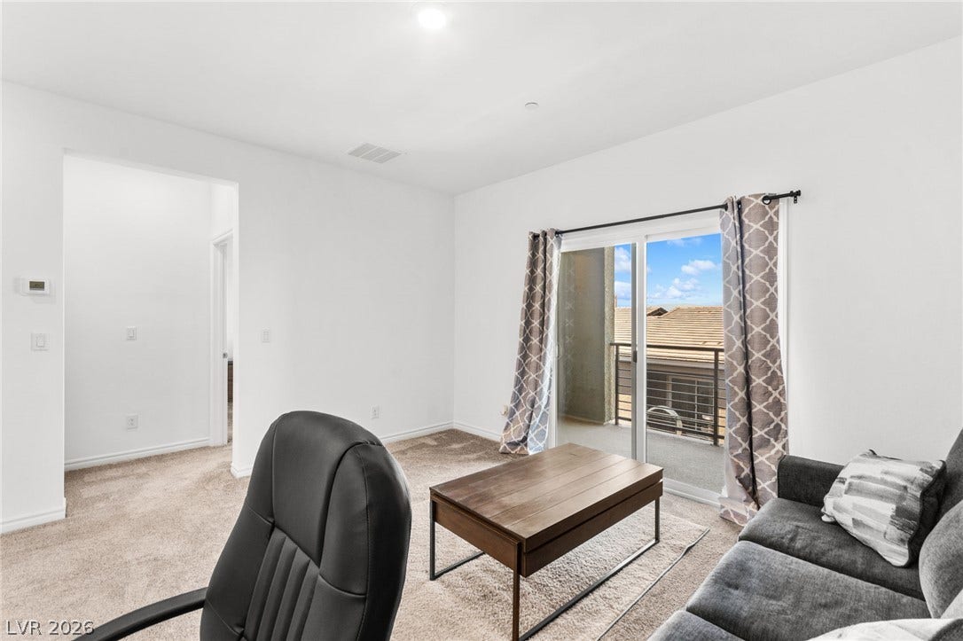 A well-lit sitting area provides direct access to a balcony, perfect for outdoor relaxation.